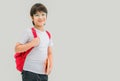 Asian child boy in glasses and red backpack holding book in his hand Royalty Free Stock Photo