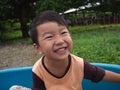 Asian child boy laughing with happy close up face outdoor with natural background. Royalty Free Stock Photo