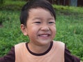 Asian child boy laughing with happy close up funny face outdoor with natural background. Royalty Free Stock Photo