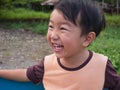 Asian child boy laughing with happy close up funny face outdoor with natural background.