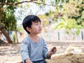 Asian child boy looking, thinking while playing clay outdoor with copy space for advertising message.