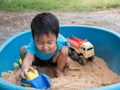 Asian child boy playing car toy in sandbox outdoor Royalty Free Stock Photo
