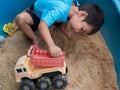 Asian child boy playing car toy in sandbox outdoor Royalty Free Stock Photo