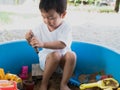 Asian child boy playing toy and sand in sandbox with happy face outdoor Royalty Free Stock Photo