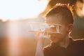 Asian child boy playing with toy wooden airplane in the park at sunset time with fun Royalty Free Stock Photo