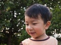 Asian child boy smiling with happy close up face while playing outdoor with natural background. Royalty Free Stock Photo