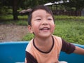 Asian child boy smiling with happy close up face while playing outdoor with natural background. Royalty Free Stock Photo