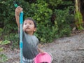 Asian child boy turning sprinkler with serious face in garden at home. Royalty Free Stock Photo