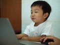 Asian child boy using notebook or computer for learning. Royalty Free Stock Photo