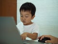 Asian child boy using notebook or computer for learning. Royalty Free Stock Photo