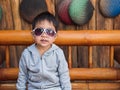 Asian child boy wearing sunglasses with happy smiling face outdoor. Royalty Free Stock Photo