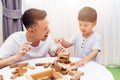 Asian child and father playing with wooden blocks in the room at Royalty Free Stock Photo