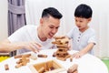 Asian child and father playing with wooden blocks in the room at home. A kind of educational toys for preschool and kindergarten Royalty Free Stock Photo