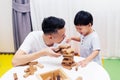 Asian child and father playing with wooden blocks in the room at home. A kind of educational toys for preschool and kindergarten Royalty Free Stock Photo