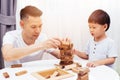 Asian child and father playing with wooden blocks in the room at home. A kind of educational toys for preschool and kindergarten Royalty Free Stock Photo