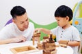 Asian child and father playing with wooden blocks in the room at Royalty Free Stock Photo