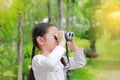 Asian child girl with binoculars in nature fields. Explore and adventure concept