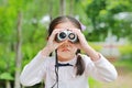 Asian child girl with binoculars in nature fields. Explore and adventure concept