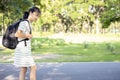 Asian child girl carrying heavy school bag or backpack,teenage feeling unhappy and pain on back, full of books on her back, going Royalty Free Stock Photo