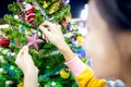 Asian child girl decorating Christmas tree with Santa Claus doll,Christmas gift box,ball at night,beautiful decorate Xmas tree, Royalty Free Stock Photo