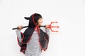 Asian child girl in demon costume holding black and red trident, happy halloween concept