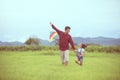 Asian child girl and father with a kite running and happy on meadow in summer in nature Royalty Free Stock Photo