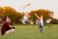 Asian child girl and father with a kite running and happy on meadow in summer in nature Royalty Free Stock Photo