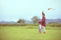 Asian child girl and father with a kite running and happy on meadow in summer in nature Royalty Free Stock Photo