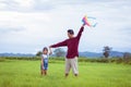 Asian child girl and father with a kite running and happy on meadow in summer in nature Royalty Free Stock Photo