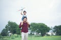 Asian child girl and father with a kite running and happy on meadow in summer in nature Royalty Free Stock Photo