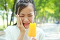 Asian child girl have hypersensitive teeth eating ice-cream,feel painful ,female teenage have sensitive teeth problem with ice- Royalty Free Stock Photo