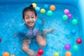 Asian Child Girl Having Fun In Garden Paddling Pool with color ball Royalty Free Stock Photo