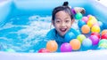 Asian Child Girl Having Fun In Garden Paddling Pool with color ball Royalty Free Stock Photo