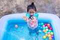 Asian Child Girl Having Fun In Garden Paddling Pool with color ball Royalty Free Stock Photo