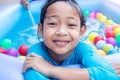 Asian Child Girl Having Fun In Garden Paddling Pool with father fill wather in background Royalty Free Stock Photo