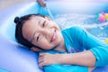 Asian Child Girl Having Fun In Garden Paddling Pool with father fill wather in background Royalty Free Stock Photo