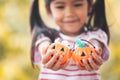 Asian child girl holding halloween bucket with sweet candy Royalty Free Stock Photo