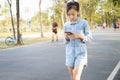 Asian child girl holding mobile and using chatting while walking outdoor on the street,female teenage looking at a phone