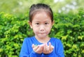 Asian child girl holding some thai sugar and fruit toffee with colorful paper wrapped in her hands. Focus at candy in her hands Royalty Free Stock Photo