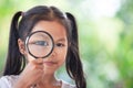 Asian child girl looking through a magnifying glass Royalty Free Stock Photo