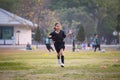 Asian child girl making funny face and running with happiness in the soccer field. Child is happy after win in game. Royalty Free Stock Photo