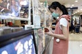 Asian child girl in a mask,buying food at shopping mall after Coronavirus quarantine Covid-19,restaurant has plastic shield