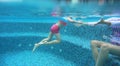 Asian child girl with mother in swimming underwater in the pool Royalty Free Stock Photo