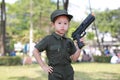 Asian child girl in pilot soldier suit costume with shooting gun up. Dream job concept