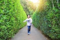 Asian child girl running in garden Maze. Kid playing in labyrinth for fun and entertainment Royalty Free Stock Photo