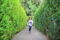 Asian child girl running in garden Maze. Kid playing in labyrinth for fun and entertainment. Back view Royalty Free Stock Photo
