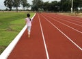 Asian child girl running on red track.