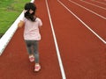 Asian child girl running on red track.