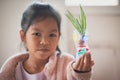 Asian child girl showing her recycle flower pot after finish painting on plastic bottle with watercolor. Royalty Free Stock Photo