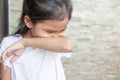 Asian child girl sneezing on hinge joints arm for protect from virus and stop coronavirus outbreak.